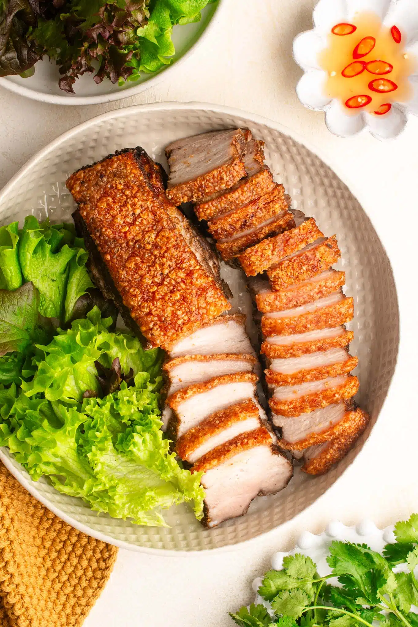 air fryer crispy pork belly in bowl with salad leaves
